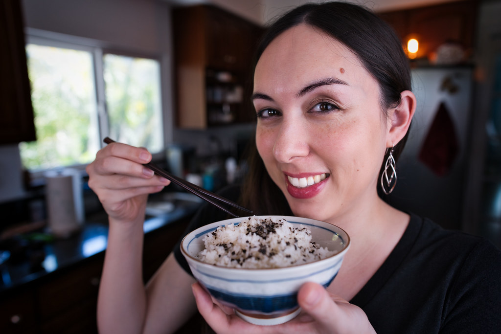 Allison holding a bowl of rice topped with furikake nori