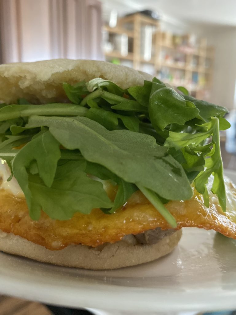 english muffin with arugula, frico egg, and sausage