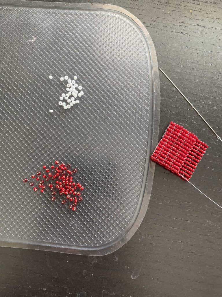 beads and a partially finished red beaded square