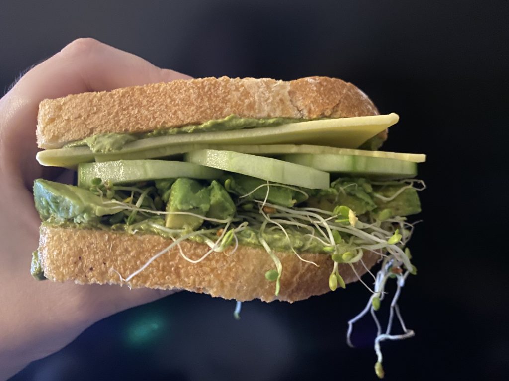 my hand holding a green goddess sandwich