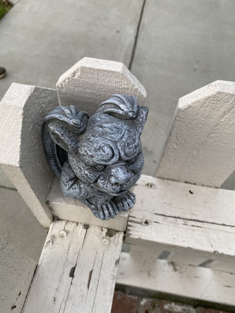 a tiny gargoyle on a fence